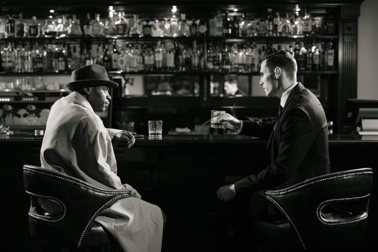 monochrome photo of men sitting in front of bar counter