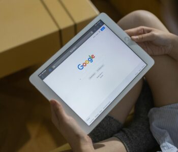 a person holding white ipad mini
