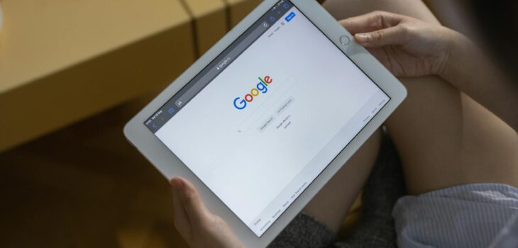 a person holding white ipad mini